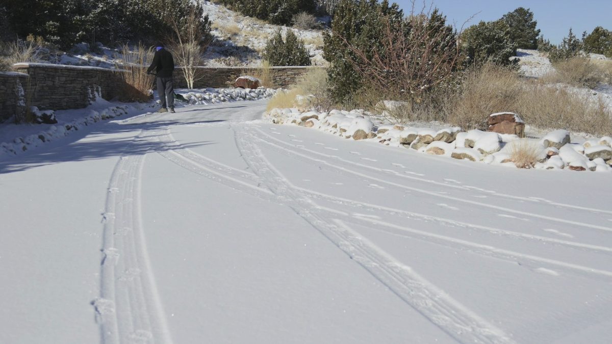 A homeowner shovels a snow-covered driveway in Placitas, New Mexico